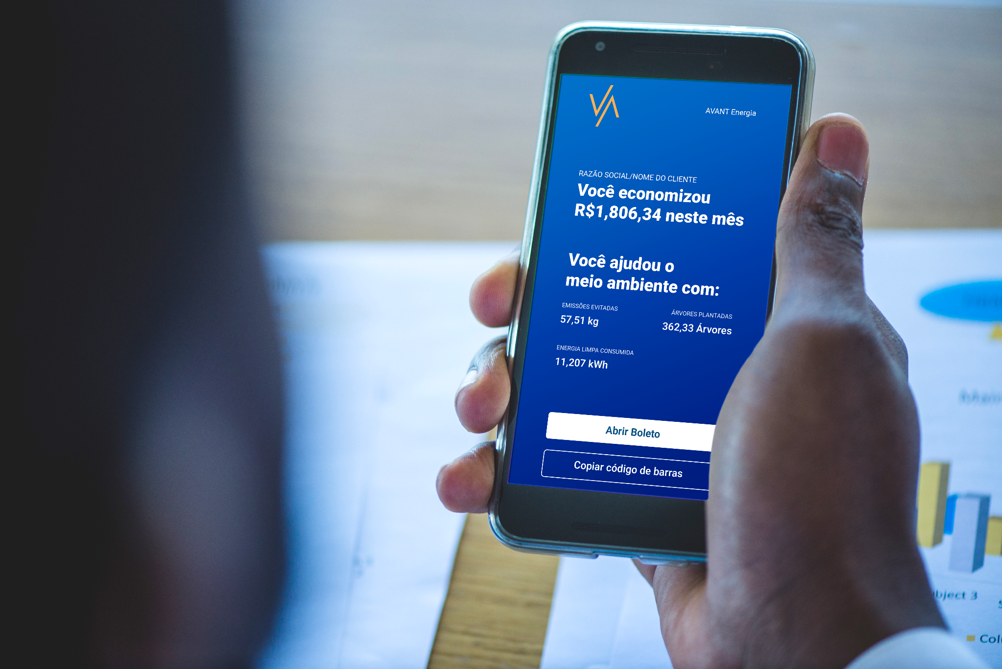 Pessoa segurando um celular com resumo de economia da Avant Energia